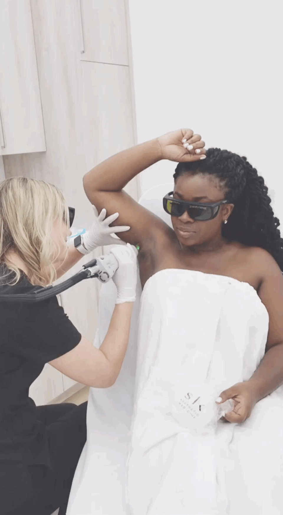 black woman receiving laser hair removal to her underarms
